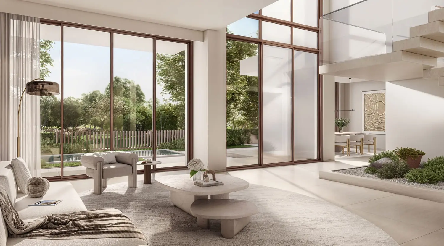 Double-height living room with garden and pool views at Bayn by Ora, Ghantoot, between Abu Dhabi and Dubai